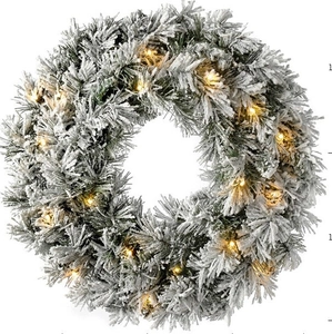 Lifelike snow-flocked Christmas wreath with warm LED lights on a white background