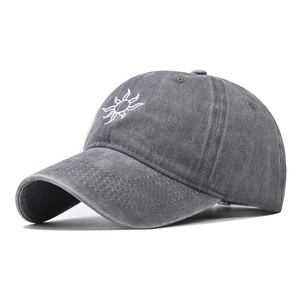Detail of grey washed cotton baseball cap featuring white sun embroidery and vintage texture