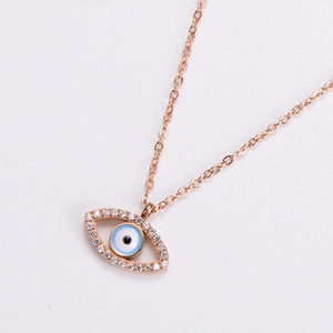 Macro shot of rose gold evil eye pendant with blue enamel and white zircon inlay