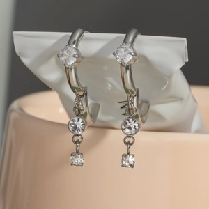 Polished silver stainless steel hoop earrings with three dangling cubic zirconia stones