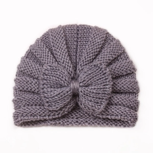 Detail of grey baby knitted hat featuring a cute bow and warm wool texture close-up