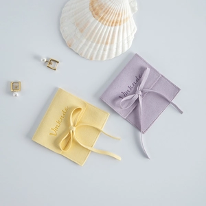 Microfiber suede jewelry pouches in yellow and purple with silk ribbon bows