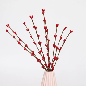 Detail showing artificial red berry branches in a ceramic vase for Christmas decor