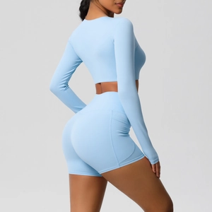 Detail van een lichtblauwe yogaset met crop top met lange mouwen en short met zakken