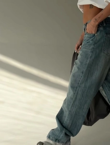Detail of high-waisted wide-leg denim jeans showing vintage wash and retro button fly