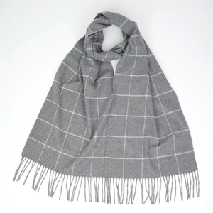 Detail of grey windowpane check scarf with soft cashmere-like texture and fringed edges
