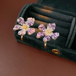 Macro shot of vintage gold flower earrings with purple crystals in a velvet jewelry box