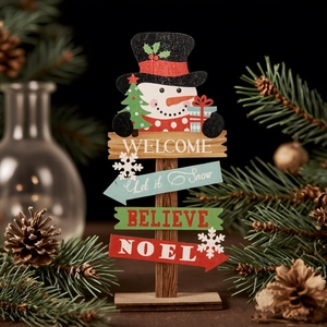 Close-up of wooden Christmas snowman sign with colorful arrows and winter decorations