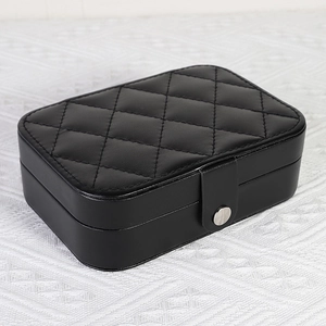 Portable black quilted faux leather jewelry box with a round silver metallic buckle
