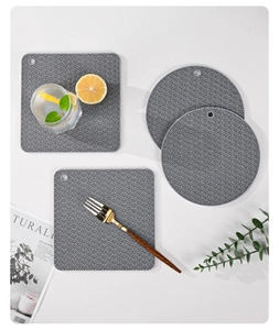 Flat lay of gray silicone heat resistant mats with wave patterns in round and square shapes