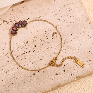 Close-up of 18K gold plated bracelet with pear-cut red garnets and K18 hallmark detail