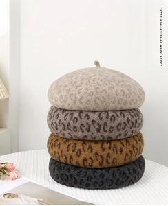 Detailed stack of leopard print wool berets in grey, brown and charcoal colors