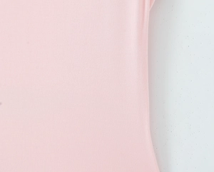 Vue macro détaillée montrant la texture du tissu en maille rose doux et le tissage fin