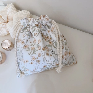 Détail d'une pochette à cordon fleurie crème avec des motifs de lapin mignons