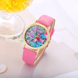 Detailed macro view of fashionable gold watch with colorful crystals and pink strap