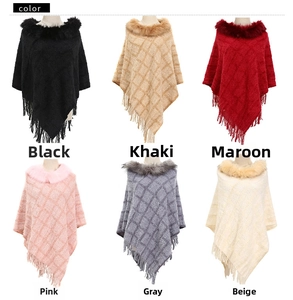 Detail showing various colors of knit ponchos with faux fur collars and fringe trim