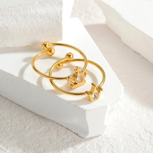 Minimalist gold plated floral crown rings with cubic zirconia stones on white pedestal