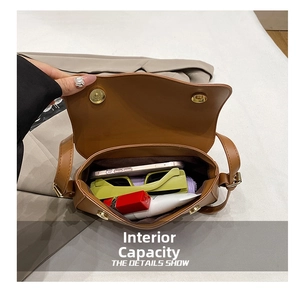 Internal capacity of the brown faux leather bag showing smartphone and makeup items