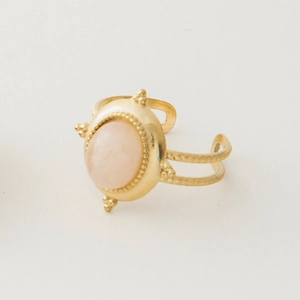 Detail of vintage gold-plated ring with oval pink stone and adjustable beaded band