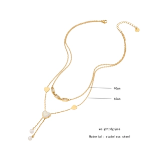 Detail of double-layer stainless steel necklace with pearl tassels and golden hearts