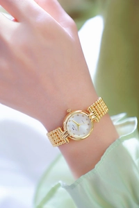 Detailed view of an elegant gold Bee Sister watch with rhinestone dial on female wrist