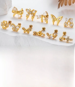 Detail showing gold cartilage studs set with butterfly and heart zircon motifs