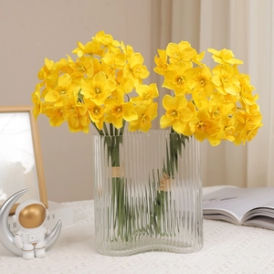 Artificial yellow narcissus bouquet in vertical striped glass vase for home decor