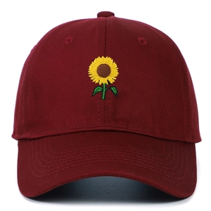Close-up of sunflower embroidery on burgundy cotton baseball cap with fine stitching