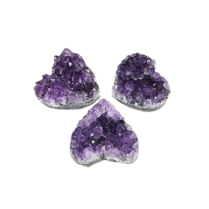 Three heart-shaped natural amethyst clusters with deep purple crystals on a white background