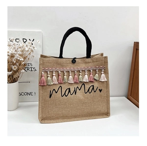 Close-up of linen tote bag with black mama script and colorful tassel fringe detail