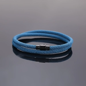 Close-up of blue braided cord bracelet with black magnetic clasp and double-loop design