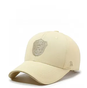 Detail of shield embroidery with R letter on light beige cotton baseball cap