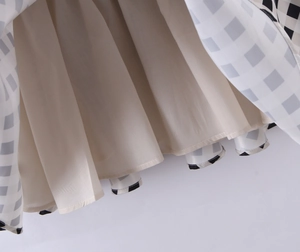 Close-up of the black and white plaid skirt hem with beige inner lining detail