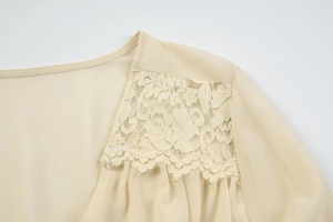Detailed close-up of beige lace patchwork on the shoulder of a soft chiffon blouse