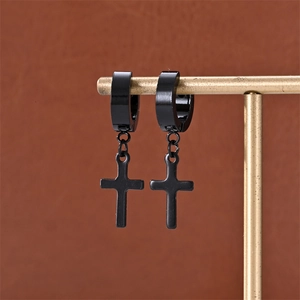 Close-up of matte black stainless steel huggie earrings with cross pendants on a display