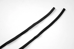 Gros plan détaillé montrant la texture tissée noire des brides du col licou de la robe