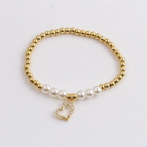 Golden beaded bracelet with white pearls and a micro-paved zircon heart pendant