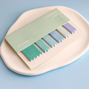 Detail of gradient index sticky notes in Morandi colors on a ceramic tray for marking