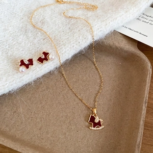 Gold-plated red enamel rocking horse jewelry set with cubic zirconia and pearl details