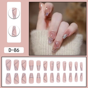 Long coffin press-on nails with nude pink base, black lines, glitter and crystal accents