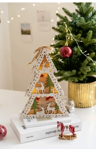 Close-up of wooden LED Christmas tree light with deer and pine tree cutout patterns