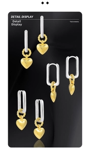 Detail of S925 silver earrings with golden heart charms and textured metallic finish