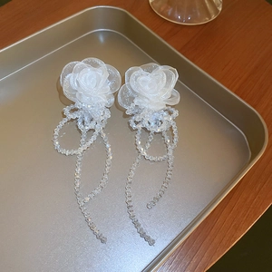 Détail de boucles d'oreilles rose organza blanc avec glands longs en perles cristal