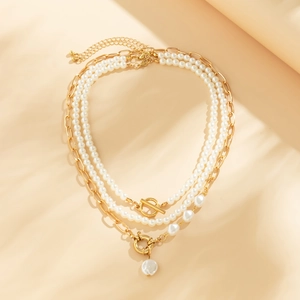 Detailed view of layered necklace featuring white imitation pearls and golden chains
