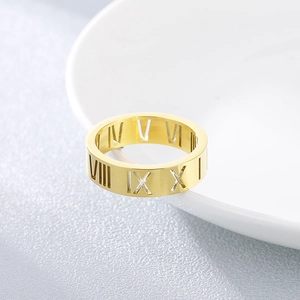 Close-up of golden stainless steel ring featuring hollow Roman numeral design details