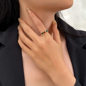 Close-up of gold ring with rainbow cubic zirconia stones on model finger