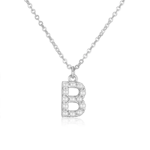 Detail shot of a silver letter B pendant encrusted with elegant white pearls on a thin chain