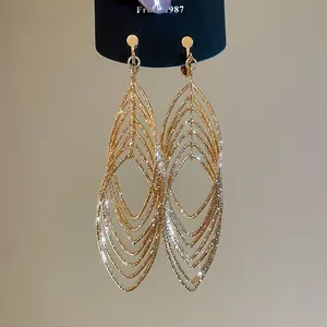 Detail of gold hollow leaf earrings with sparkling texture and layered curved design