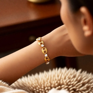 Close-up of golden pig nose link bracelet with zircon inlay on woman wrist