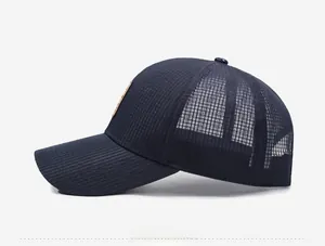 Detail view of breathable side mesh and brown square patch on navy blue baseball cap